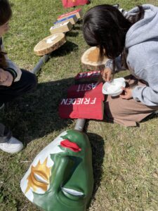 eine grün-weiß bemalte Maske liegt auf dem Rasen