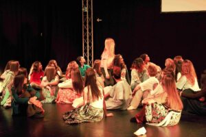 jugendliche Tänzerinnen in sitzenden Positionen; Blick auf ein Mädchen in der Mitte