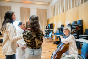 Cellistin im Gespräch mit drei Mädchen